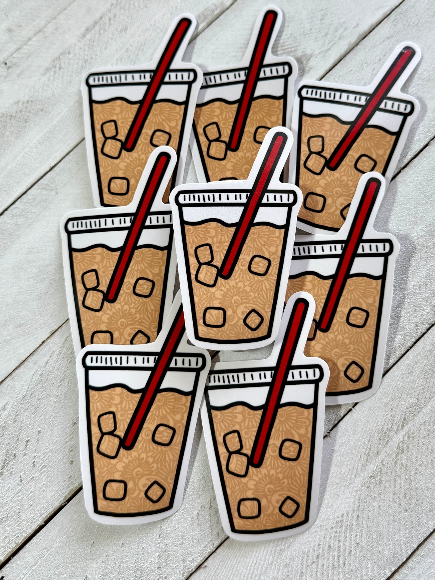 Sticker design of iced coffee cups with straws on a wooden surface