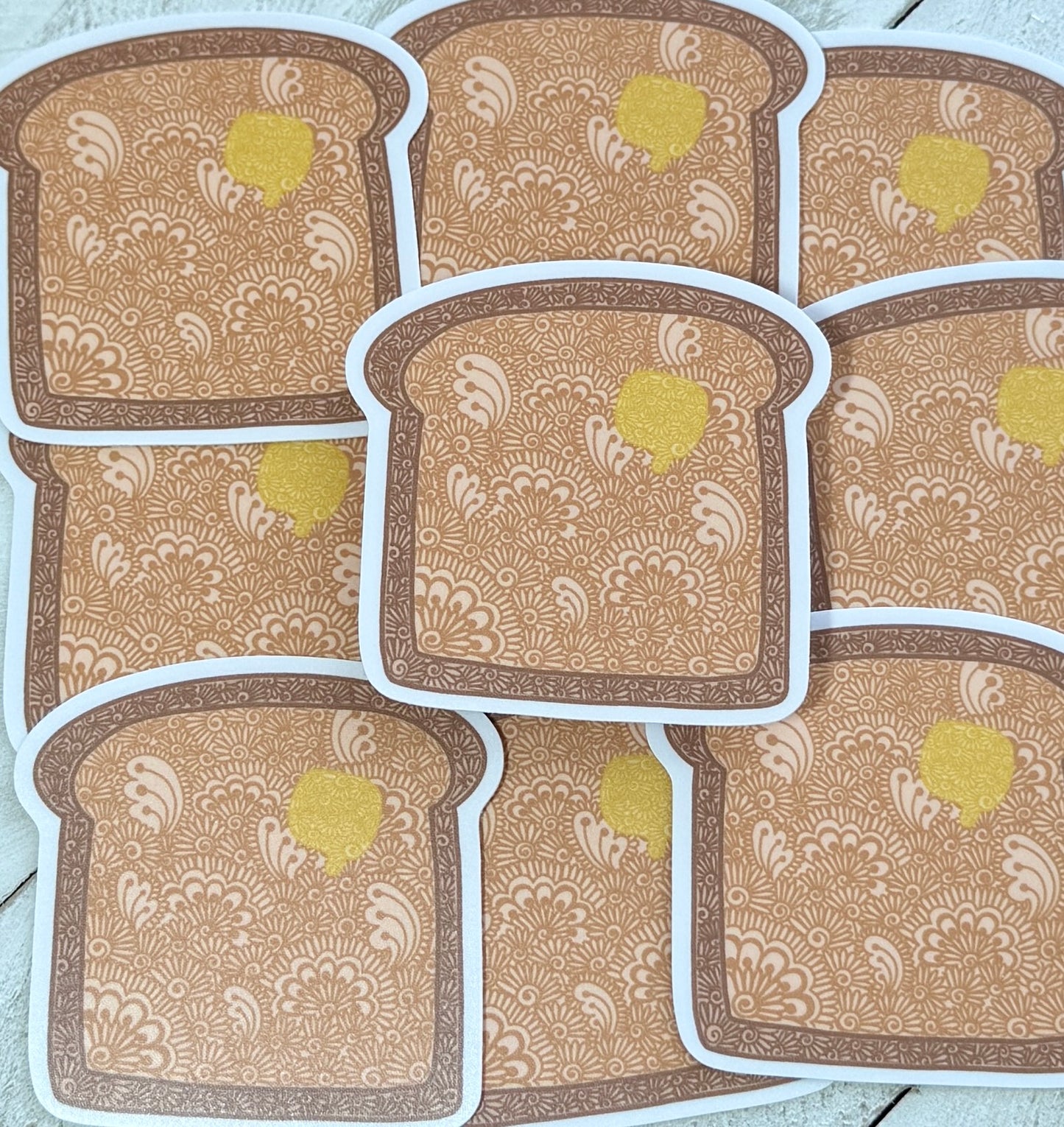 Patterned toast stickers with a yellow center on a light wooden surface