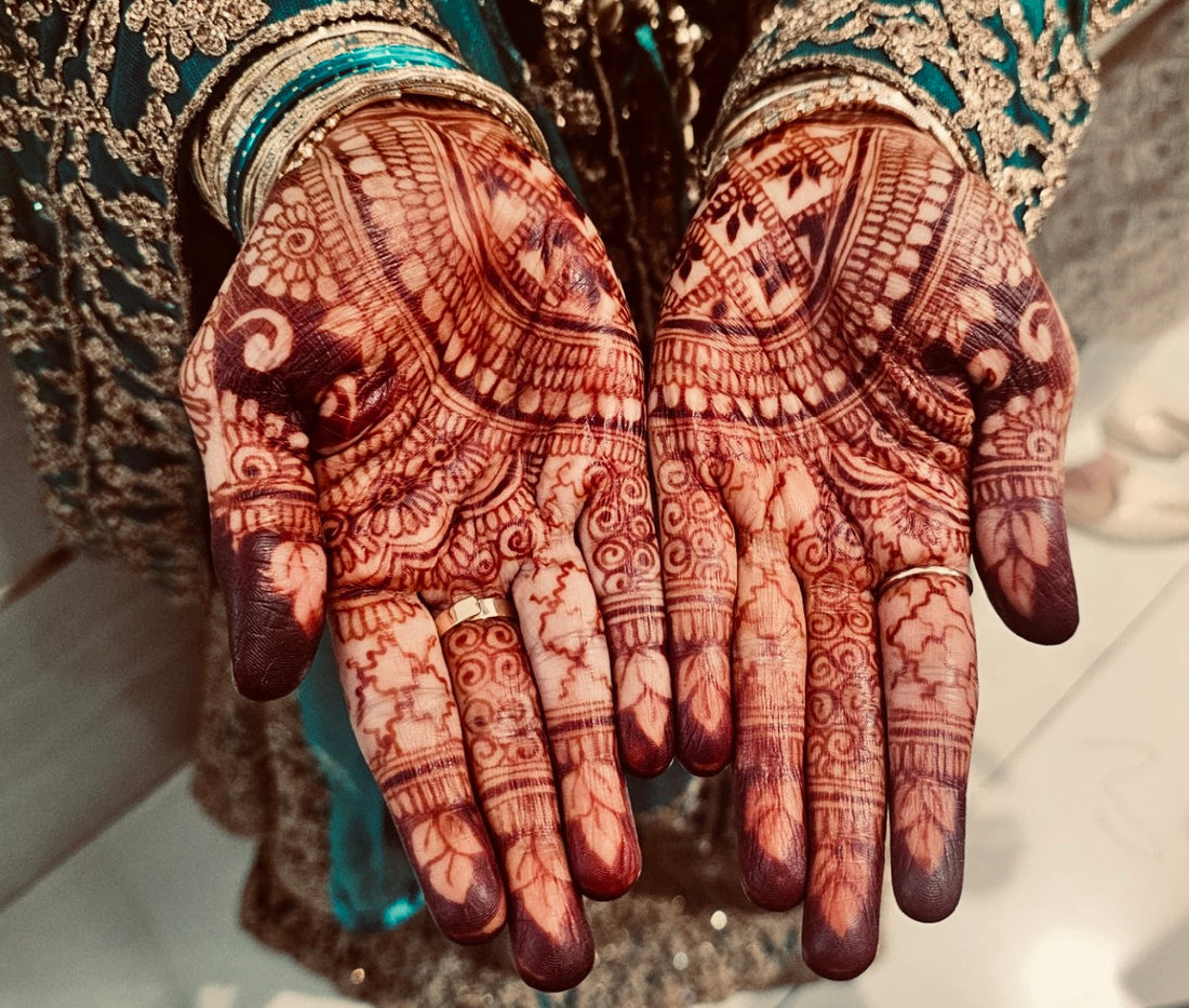 This image depicts an intricate henna design with a deep stain to the palm of the hands 
