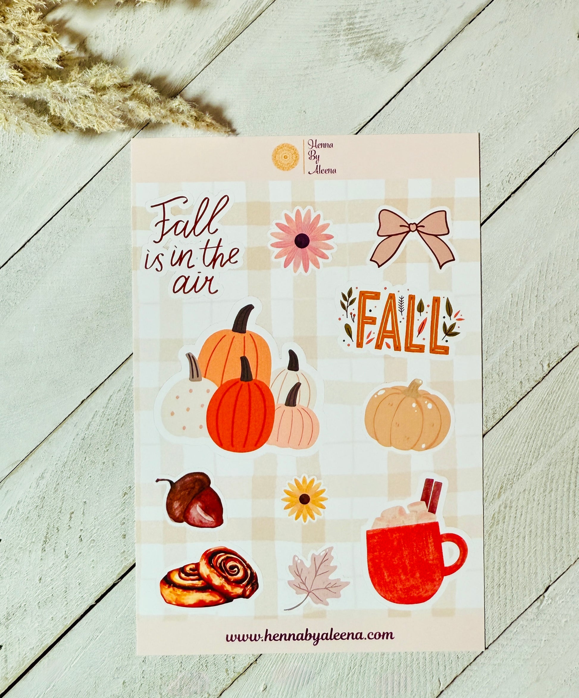 Sticker sheet with fall-themed designs on a wooden surface