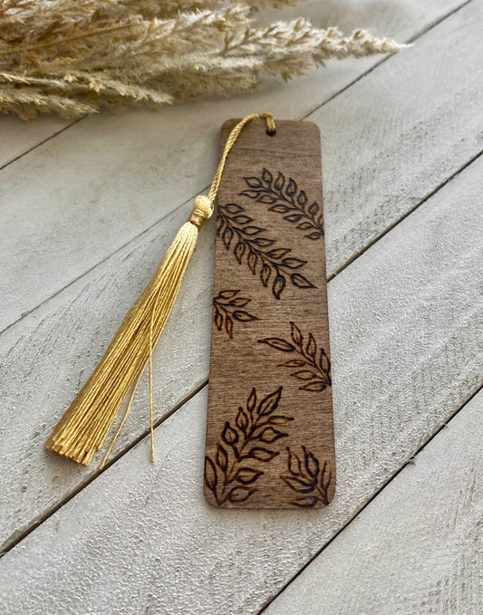 Henna vines bookmark with a gold tassel on a wood background 