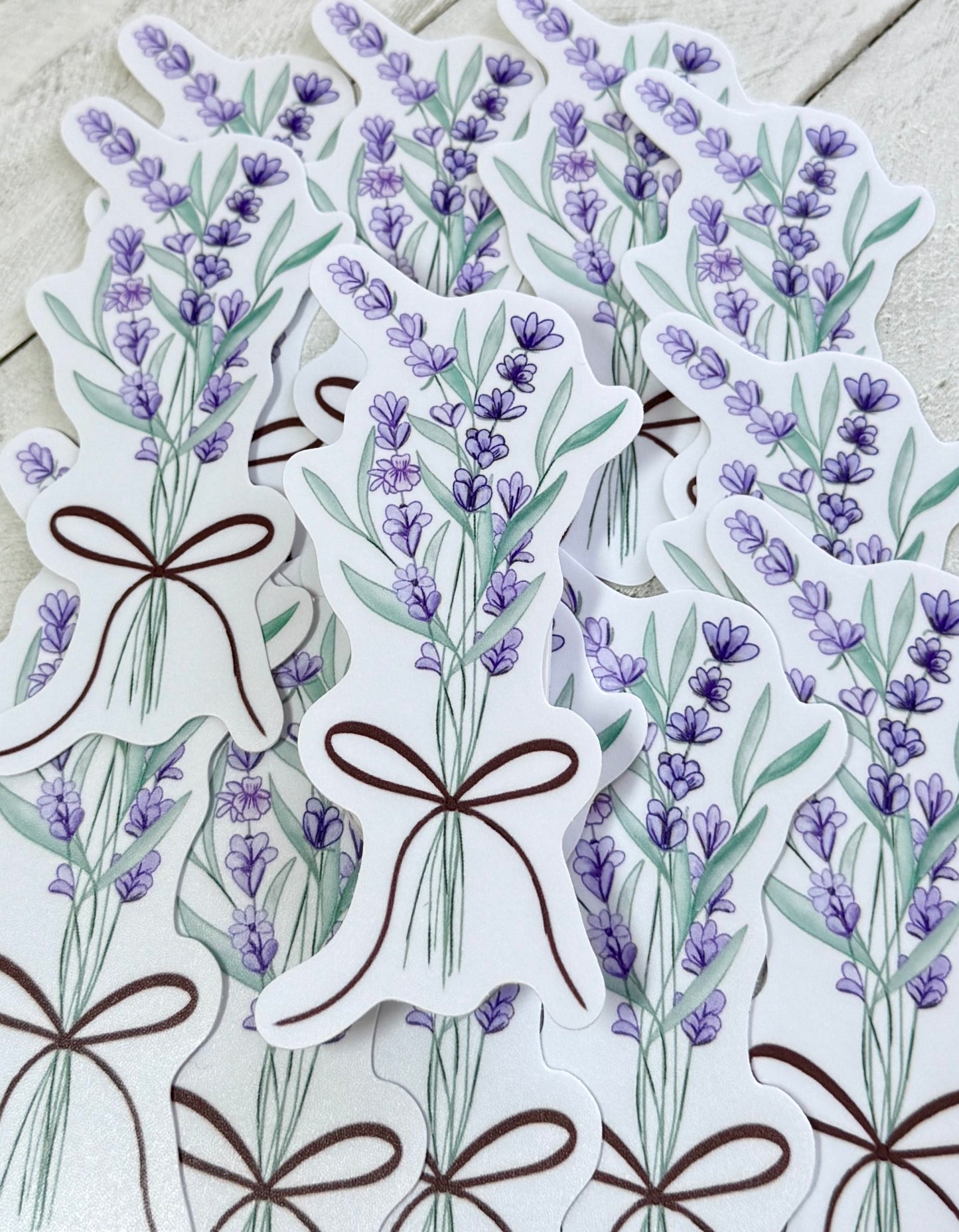 Stickers with lavender designs and brown ribbons on a wooden surface