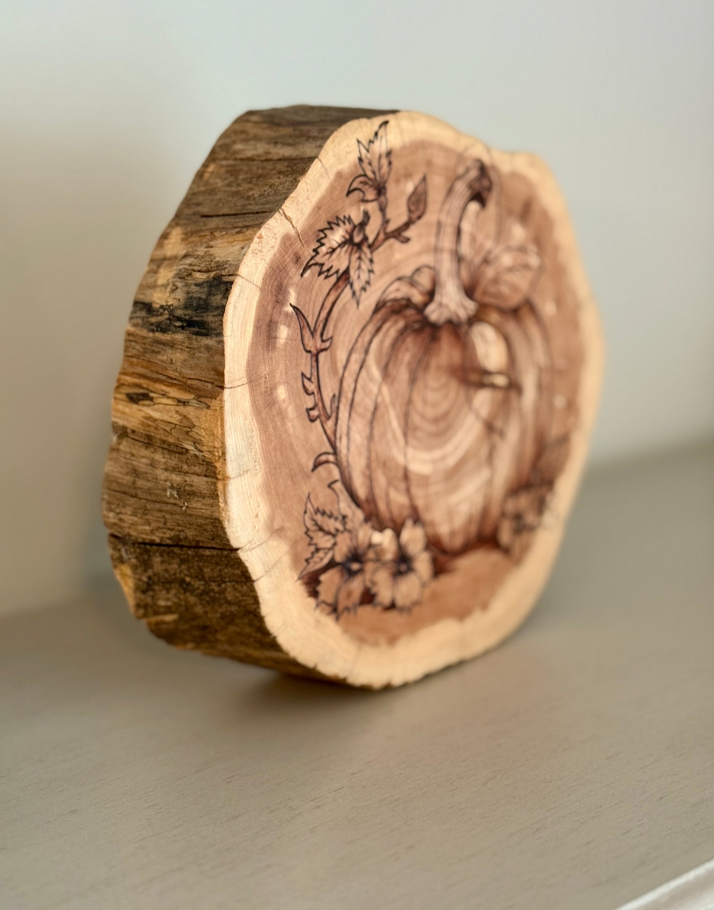 Wooden ring with floral engraving on a neutral background