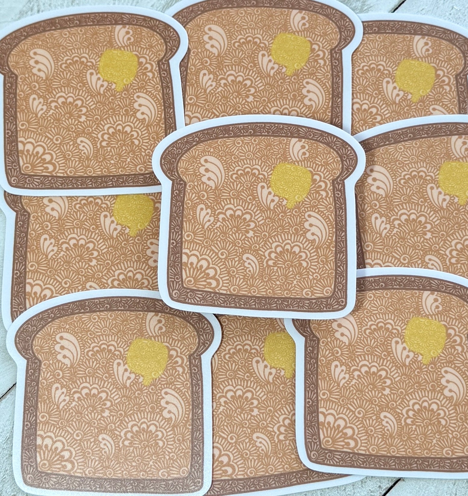 Patterned toast stickers with a yellow center on a light wooden surface