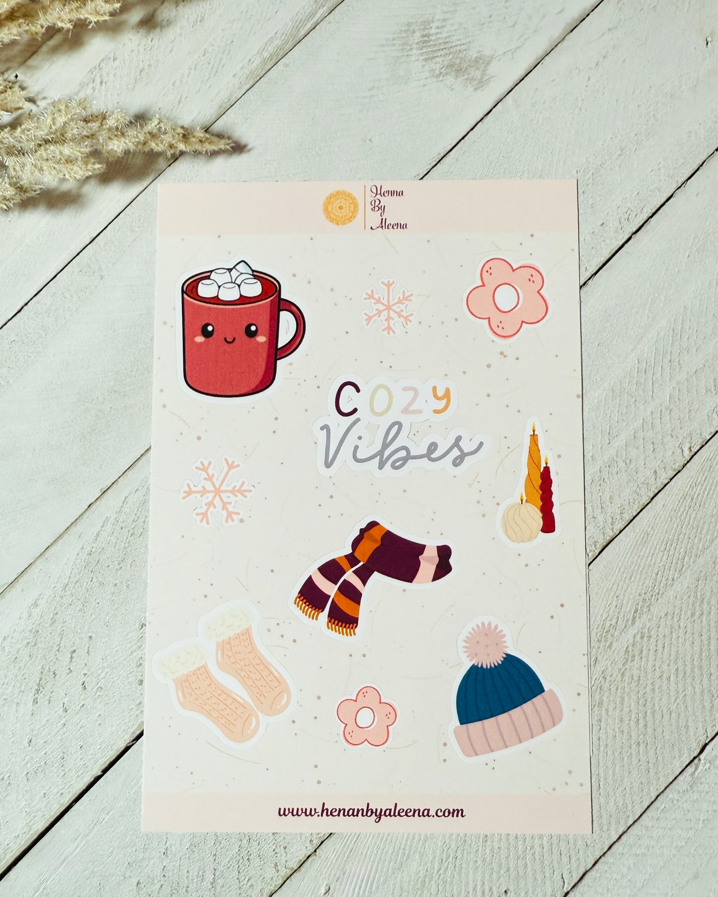 Sheet of stickers with 'Cozy Vibes' text and illustrations on a light wooden surface.