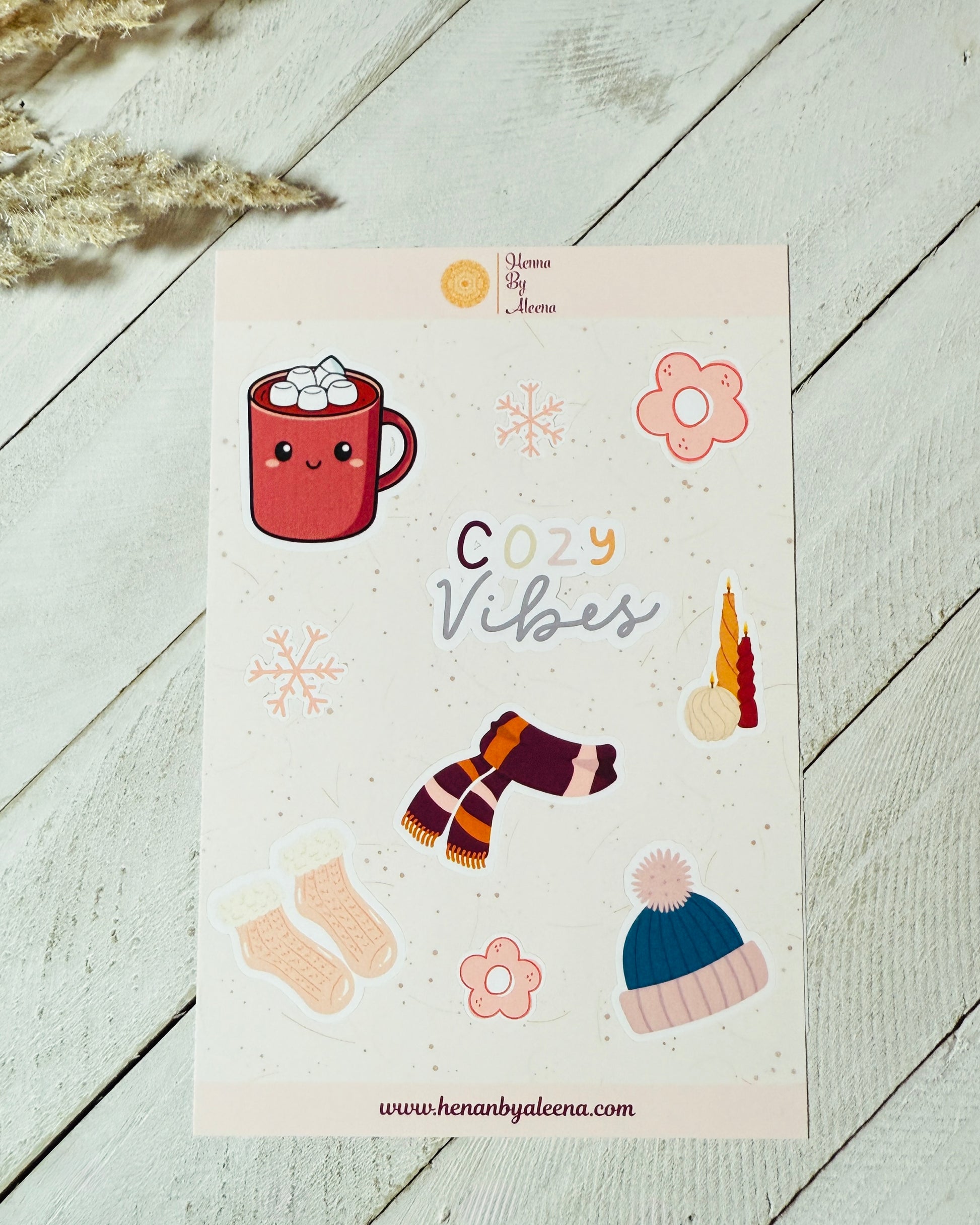 Sheet of stickers with 'Cozy Vibes' text and illustrations on a light wooden surface.